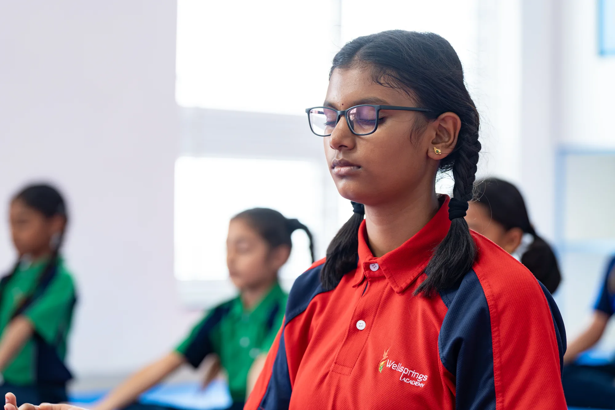 A Wellsprings student sitting quietly with her eyes closed