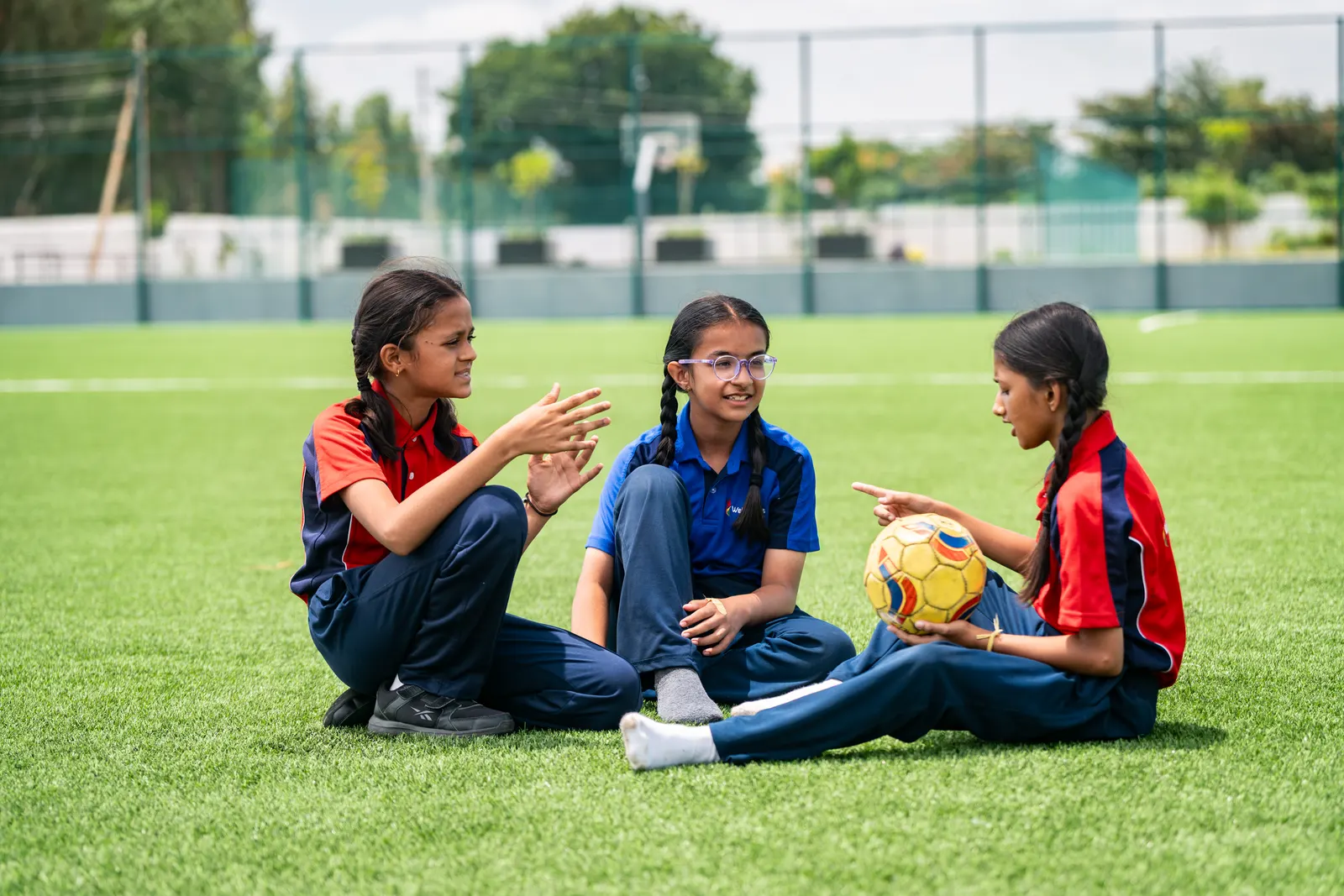 Three Wellsprings students talking together on the field