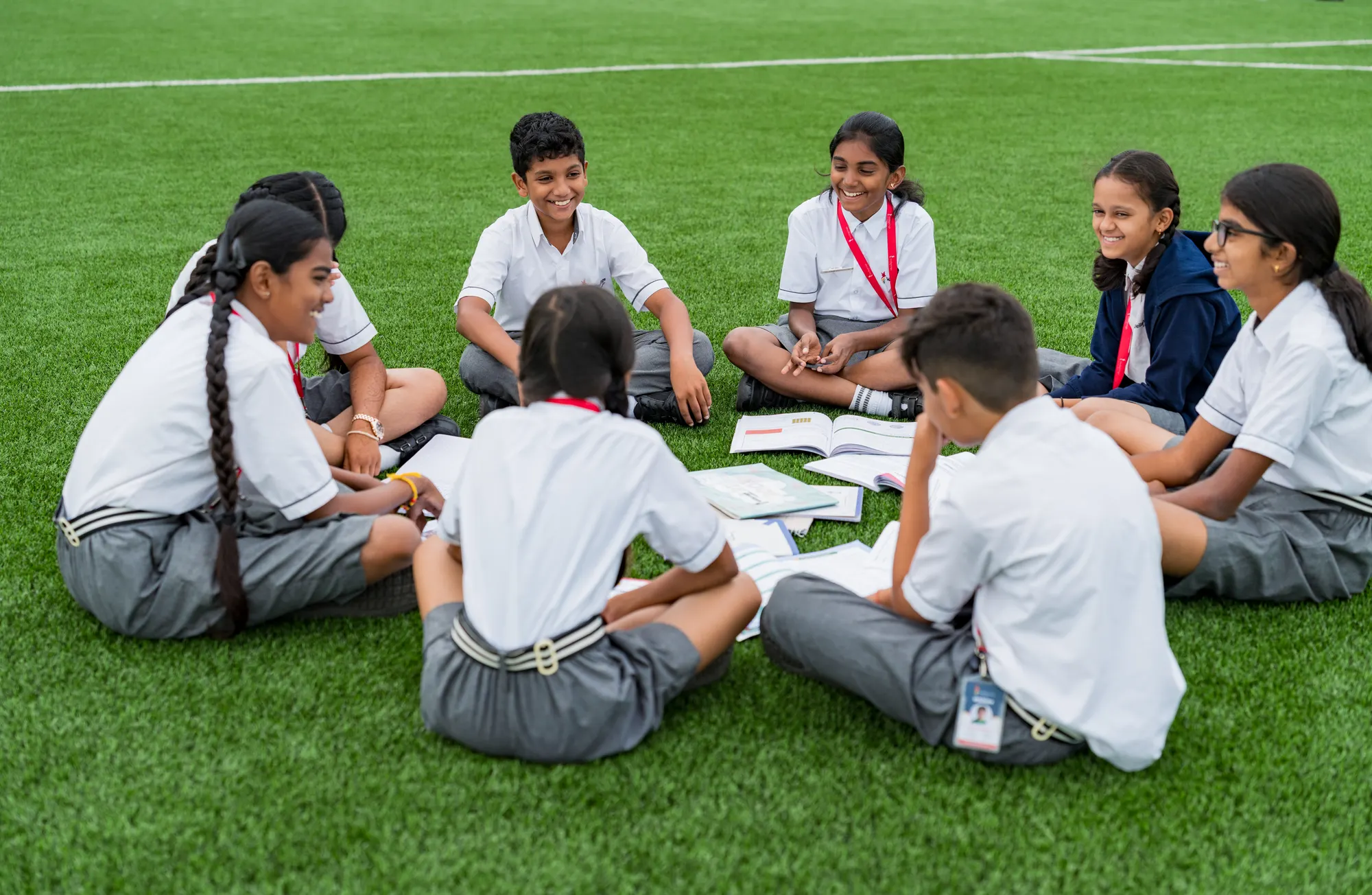 Wellsprings students sitting in a circle on the field