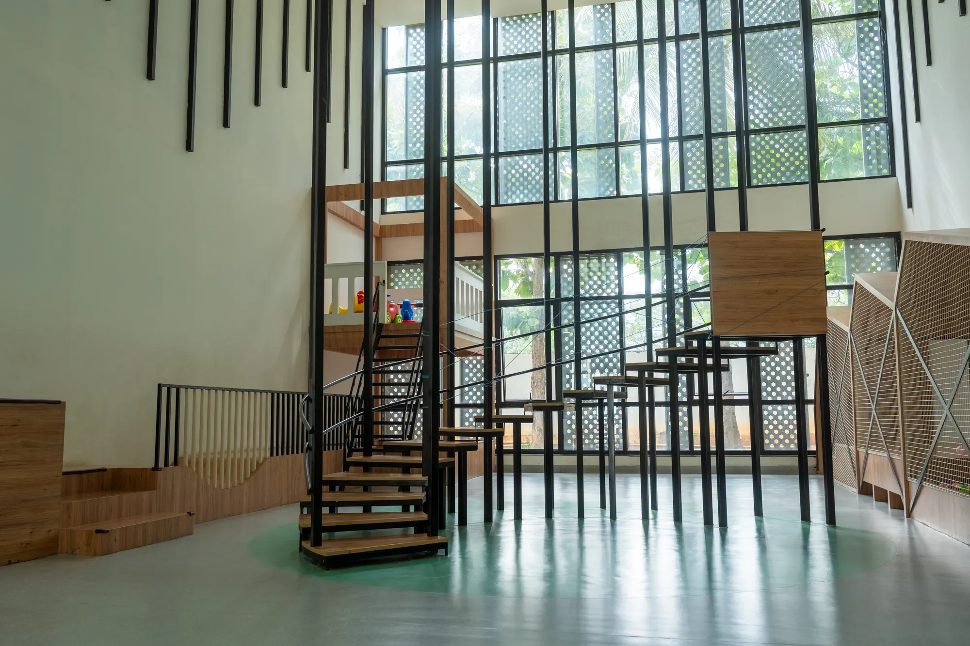 An indoor play space with a staircase and tall windows
